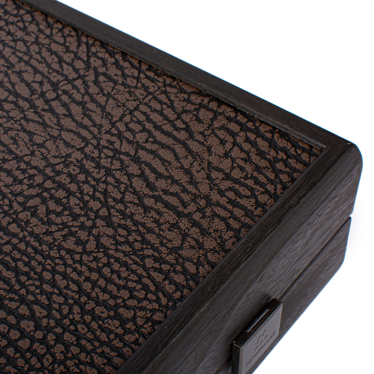 Manopoulos premium leatherette backgammon board corner with a textured dark playing surface woodgrain frame and polished metal clasp detail