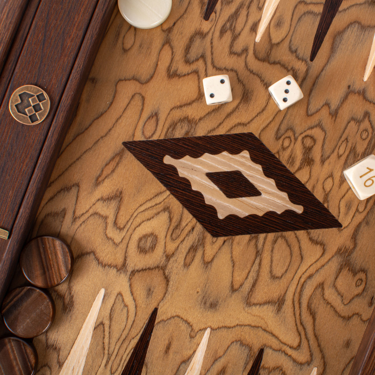Close view of a handcrafted walnut burl backgammon board with decorative inlay details dice and wooden playing pieces by Manopoulos Greece