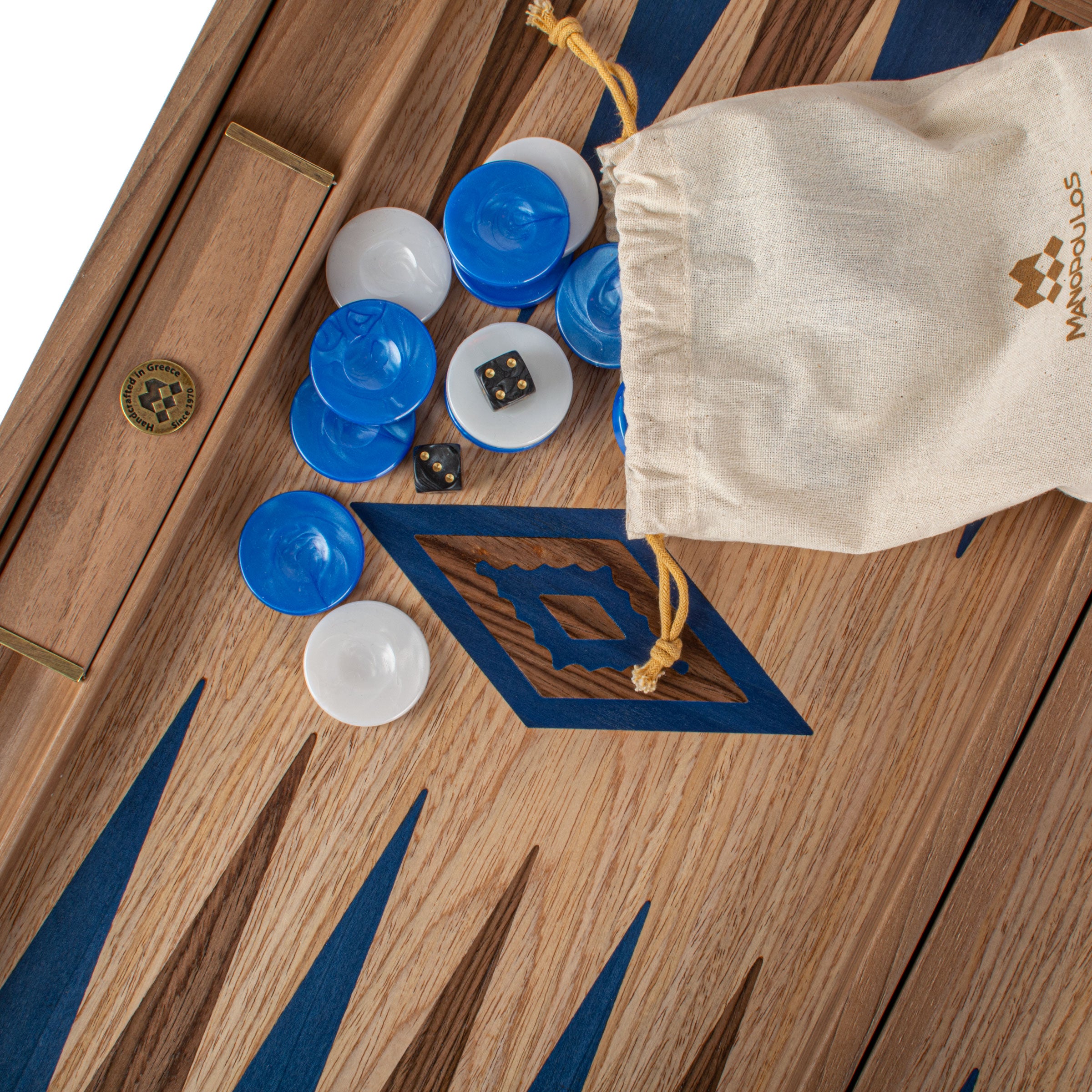 Handcrafted Oak/blue & American Walnut Backgammon Set with Side Racks - Elegant Marquetry Design by MANOPOULOS Chess & Backgammon, featuring artisan-made game pieces spilling from a branded linen pouch on a luxury wooden board, showcasing traditional Greek craftsmanship and timeless design.
