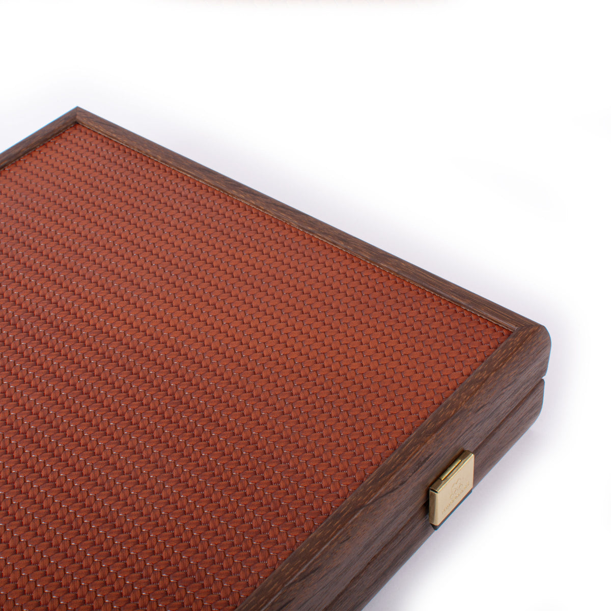 Close view of a premium mahjong set case with a reddish brown knitted leather surface, dark wooden frame, and brass clasp by MANOPOULOS Chess and Backgammon