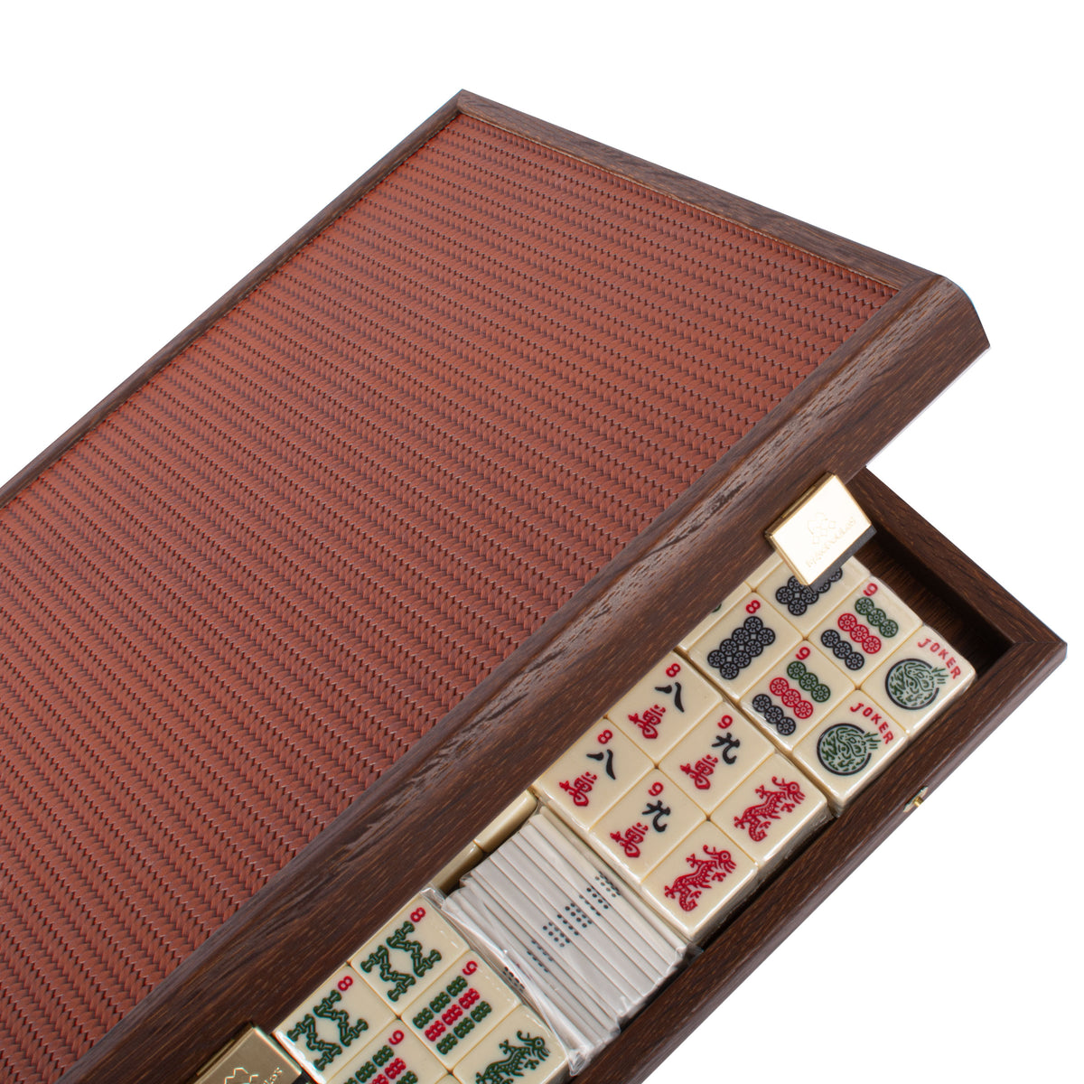 Premium mahjong tiles displayed in an open dark brown knitted leather wooden case from MANOPOULOS Chess and Backgammon artisan board game craftsmanship