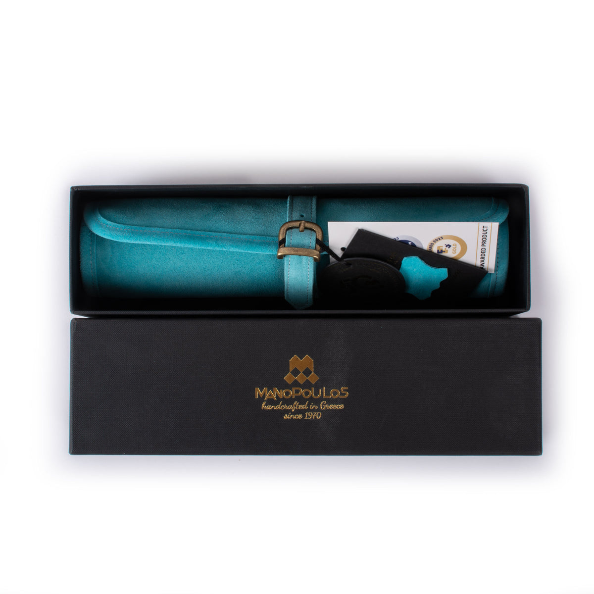 Open black presentation box holding a turquoise suede roll up backgammon set with strap and accessories by MANOPOULOS Chess and Backgammon