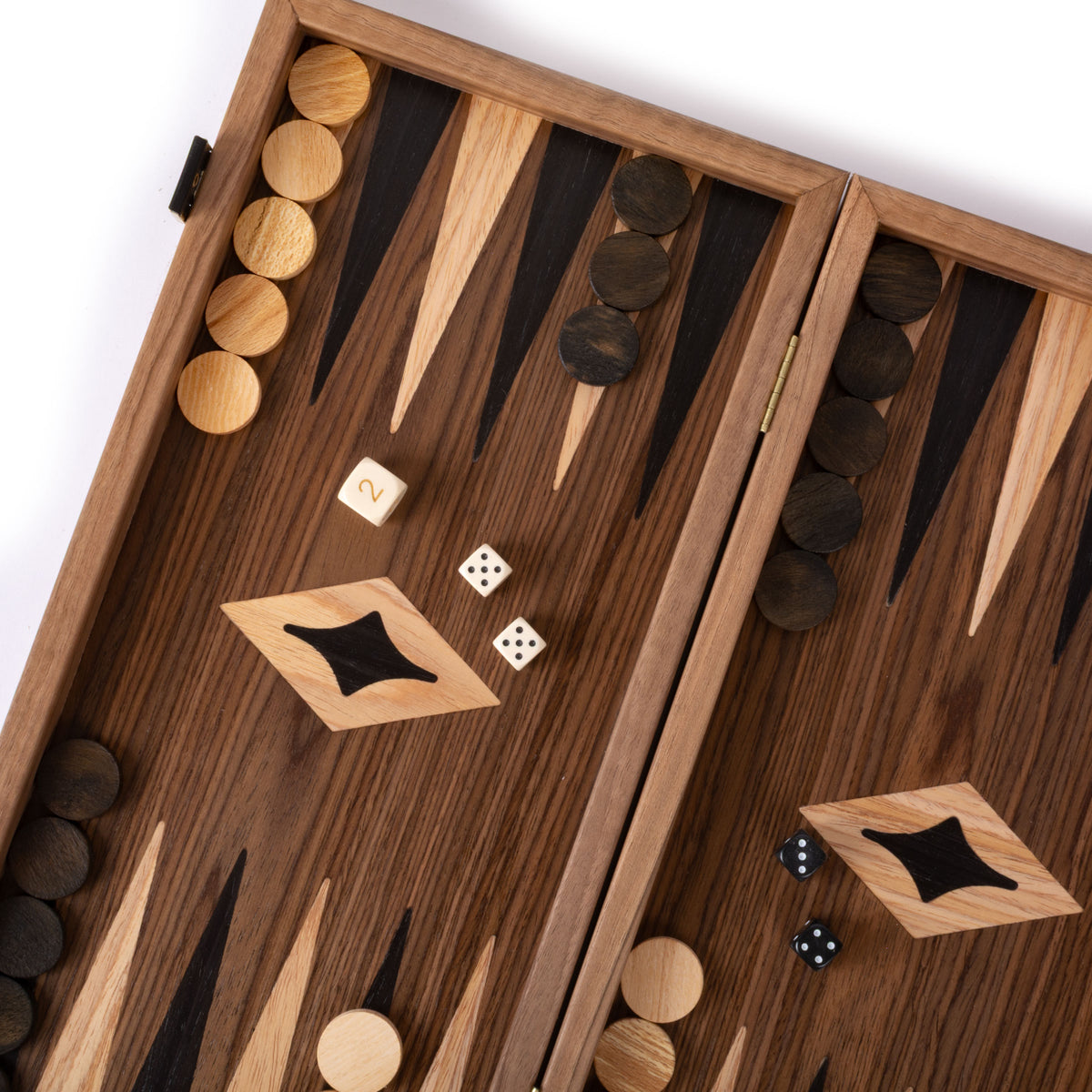 Open wooden backgammon board with dark and light playing pieces, dice, and geometric inlays displayed across a richly grained wood playing surface