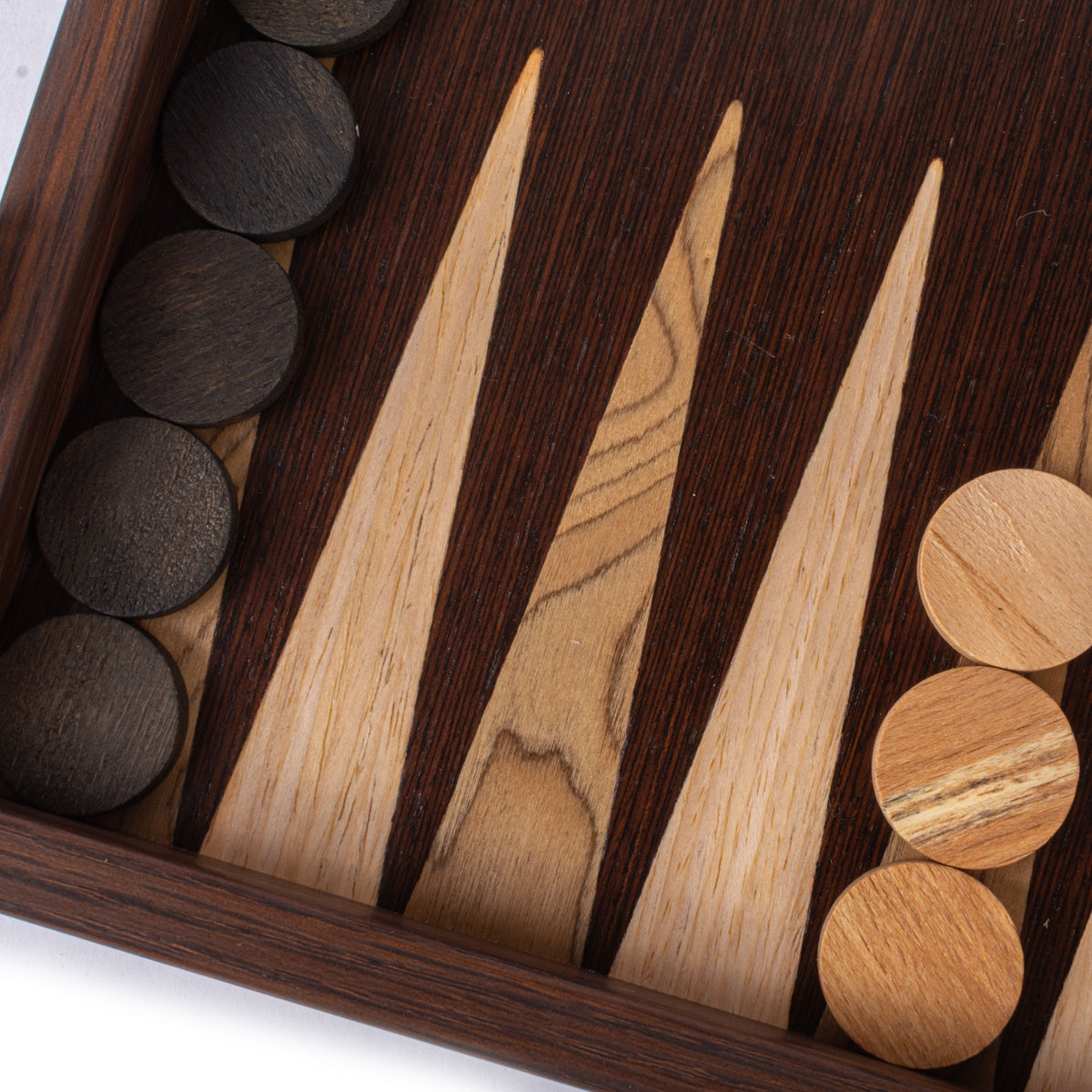 Close view of a handcrafted wenge and walnut burl backgammon board with striking marquetry points and contrasting wooden checkers by MANOPOULOS Chess and Backgammon