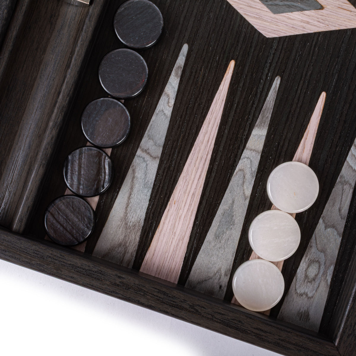 Close up of a luxury backgammon board with pearly grey and dark playing pieces on striped wood veneer by MANOPOULOS Chess & Backgammon