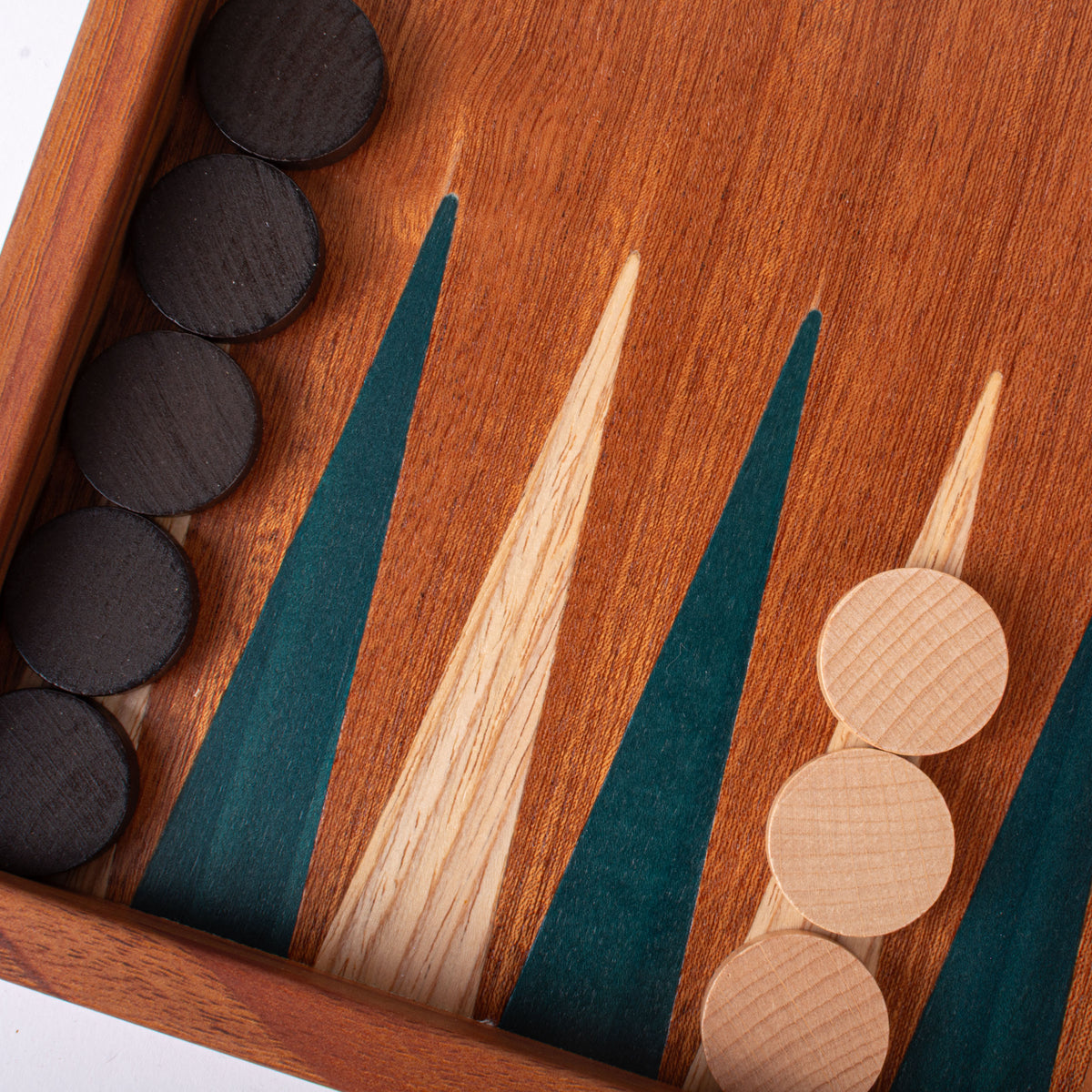 Close view of a handcrafted mahogany backgammon board with green and natural marquetry points and wooden playing pieces showcasing Greek craftsmanship and luxury design